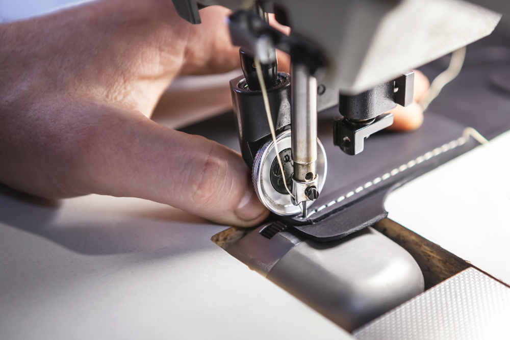 A skilled workers meticulously sew products.