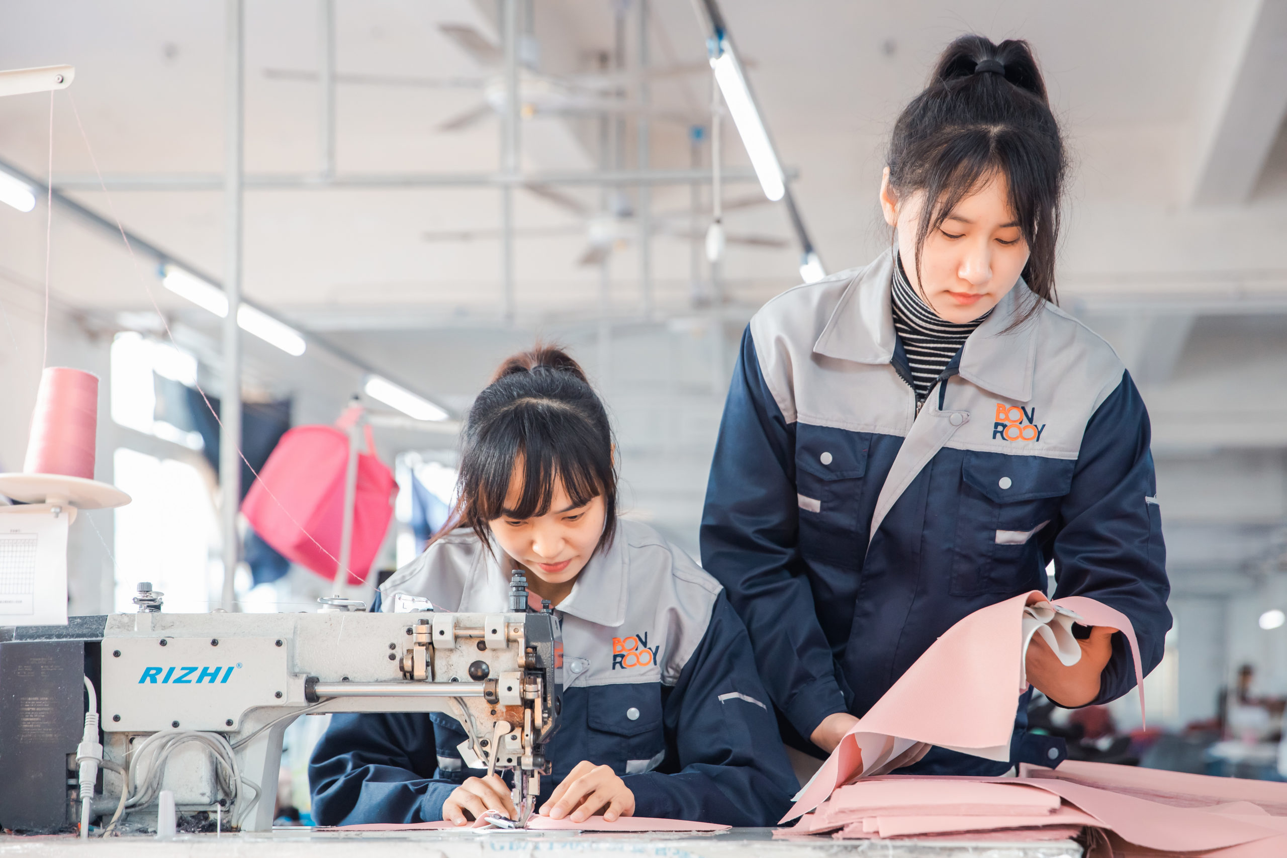 A worker meticulously checks the quality of fabric on the production line.