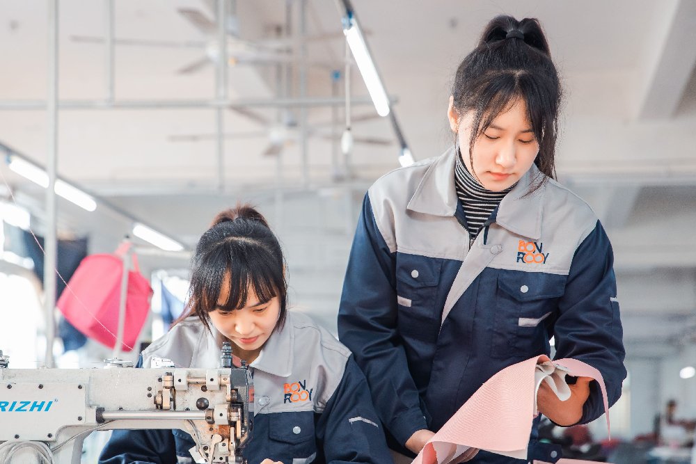 A worker meticulously checks the quality of fabric on the production line.